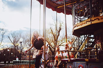 woman, holding, black, sun hat, standing, white, horse carousel, daytime, Girl, Attraction, Hat