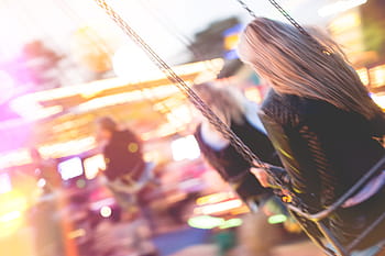 Joven, niña, disfrutando, loco, paseo, carrusel de oscilación, carruseles, colorido, noche, fiesta, festival