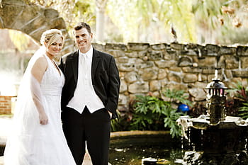 man, black, suit, woman, white, wedding dress, standing, garden fountain, daytime, bride, groom
