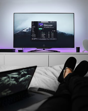 person, reclining, bed, flat, screen tv, displaying, spotify, tv, monitor, screen, bedroom