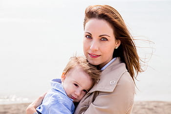 woman, brown, top, carrying, toddler, blue, mother, son, mom and child, mother and son, parents and children