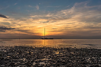 sunset, pebble beach, sunset beach, beach sunset, pebbles, calm water, sailboat, evening sky, golden hour, tranquil scene, natural beauty