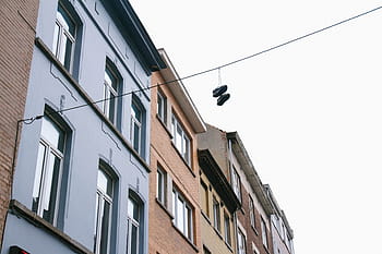 pair, shoes, hung, black, cable, daytime, white, brown, high, rise, buildings