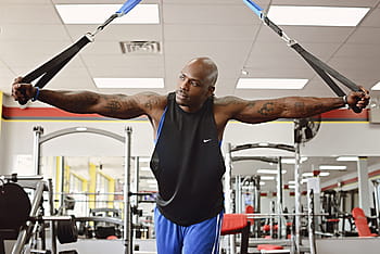 man, black, tank, top, using, resistant, bands, inside, gym, man in black, tank top